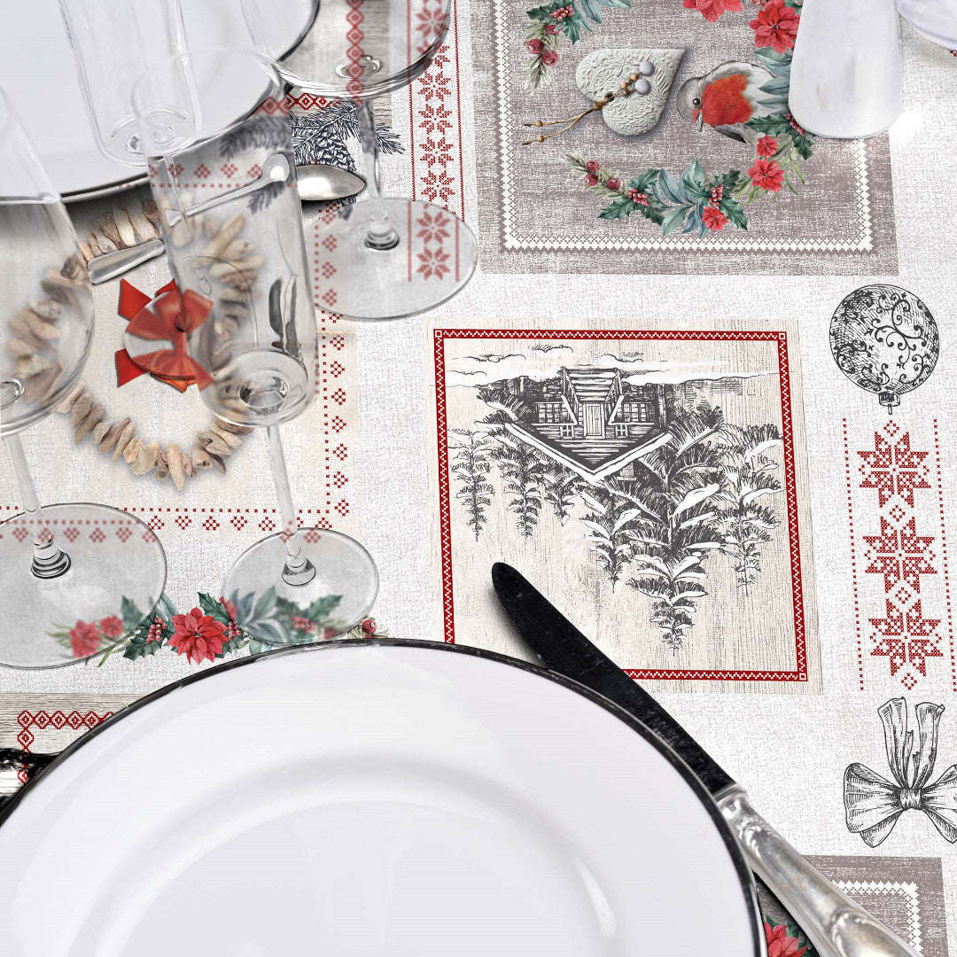 Nærbilde av borddekking med julevoksduk og fjellmotiver