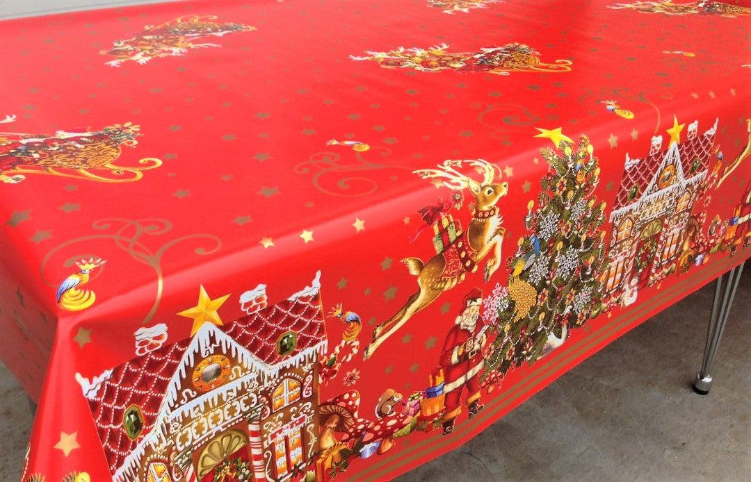 Jul i Kakehuset voksduk på spisebord med julemotiver som grantrær og pepperkakehus