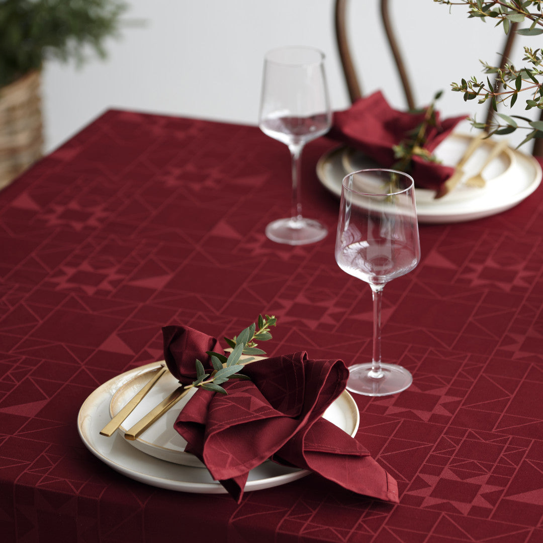 Nærbilde av oppdekking med Södahl Star Damask Juleduk Rød og glasspynt 140 × 220