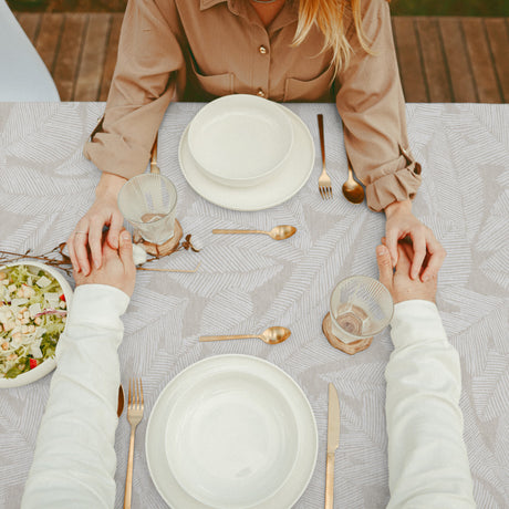 Nordfavn Edna – Akrylduk med diskré bladmønster på sandfarget bunn, bord