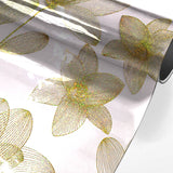 Danela Gold – Gjennomsiktig voksduk, strekblomster og glittereffekt, rullet