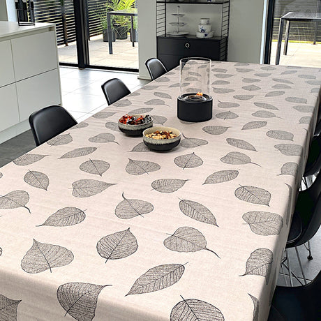 Voksduk med detaljerte sorte blader og hørlook på bord