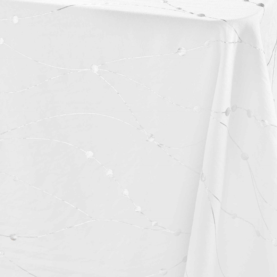 Nærbilde av hjørnet på Firmament Metallic hvit duk med sølvstjerner