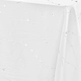 Nærbilde av hjørnet på Firmament Metallic hvit duk med sølvstjerner