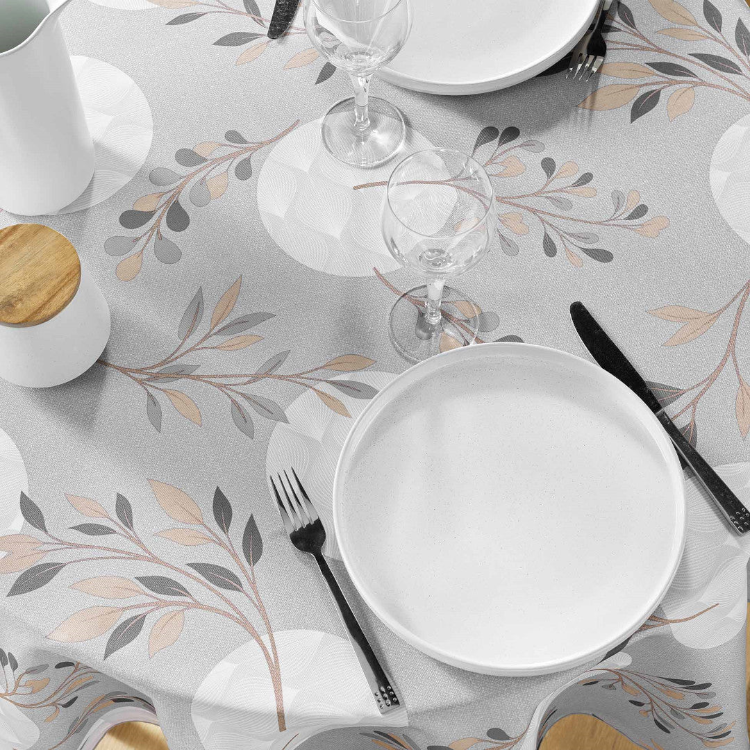 Nærbilde av grå duk med bladtrykk og bestikk
